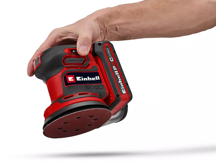Hands attach a sanding sheet to the sanding disk of the Einhell cordless orbital sander TE-RS 18/28 Li - Solo using a hook-and-loop fastening system.