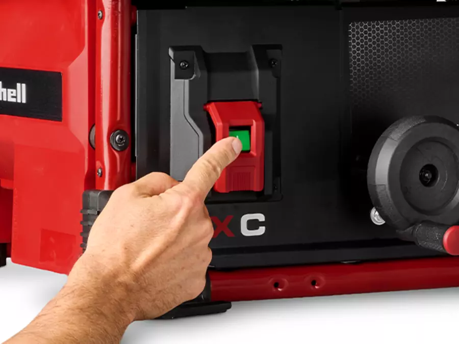 A finger points to the green power button on the Einhell cordless table saw TE-TS 36/10 T Li - Solo.