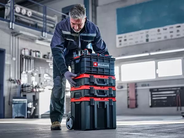 Person stacking the Einhell Pro System Toolbox onto a compatible Pro System Dolly.