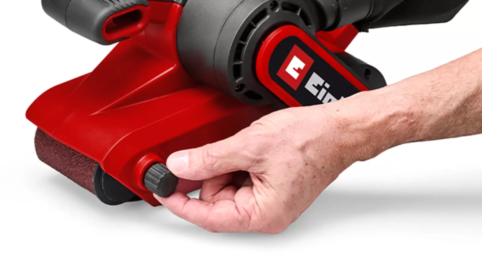 Une main actionne le dispositif de réglage de la bande abrasive de la ponceuse à bande Einhell TC-BS 800 afin de centrer la course de la bande.