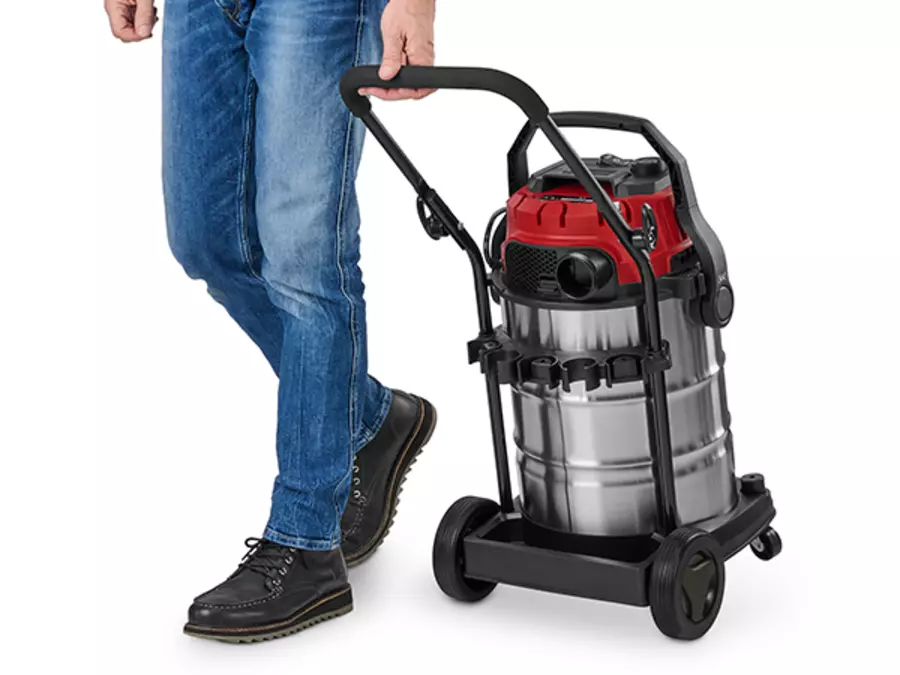 A user carries the Einhell wet/dry vacuum cleaner TE-VC 3080 SACL using the ergonomic carrying handle on the top.